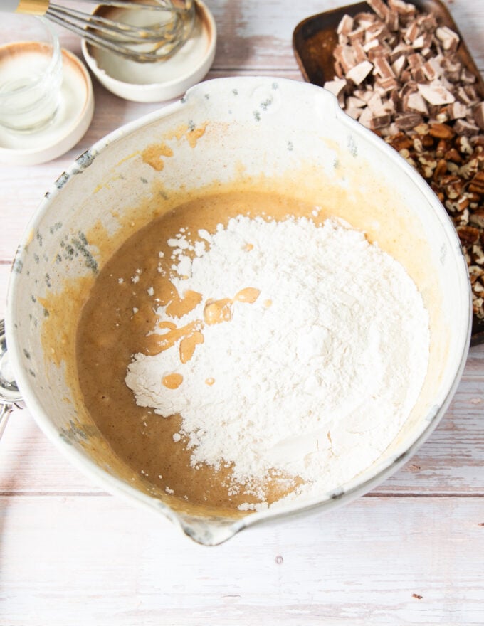 dry ingredients are added to the wet ingredients in a large bowl to make banana bread muffins
