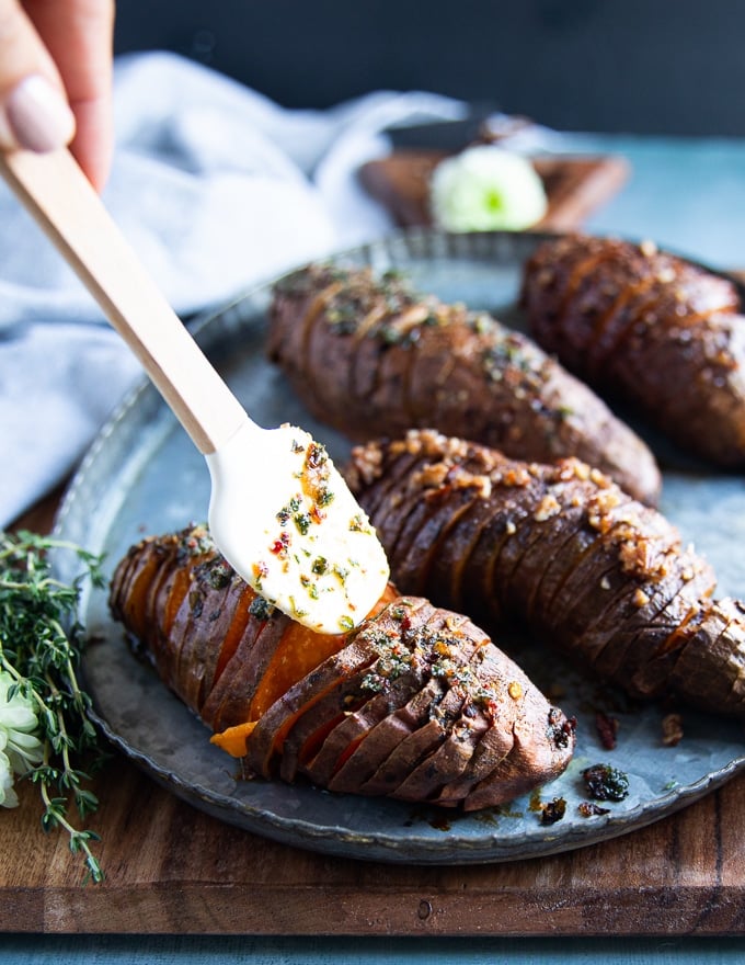 Cooked hasselback sweet potatoes out of the oven or air fryer and drizzled with extra butter sauce on top