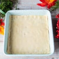 The shortbread crust or pie dough fitted into a 9 inch square pan ready to bake before making the pecan pie bars filling