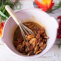 Pecans added into the bowl after the caramel sauce is complete