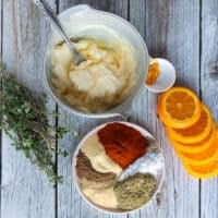 Ingredients for the turkey butter including a bowl of soft butter, some orange zest and a plate full of spices like salt, pepper, paprika, oregano, onions powder, garlic powder