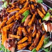 Sweet potato salad all dressed up on a plate with avocados, cooked wild rice, sweet potatoes, apples,onions and cranberries