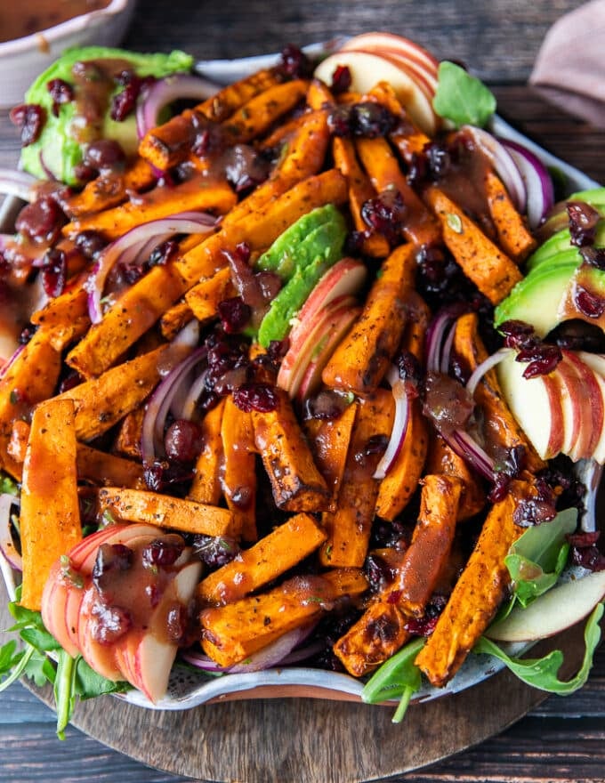 Sweet potato salad all dressed up on a plate with avocados, cooked wild rice, sweet potatoes, apples,onions and cranberries