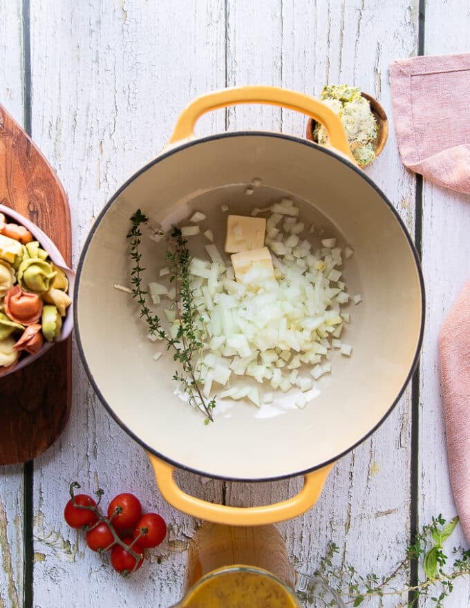 The diced onions and thyme are added to a pot to sautee with butter