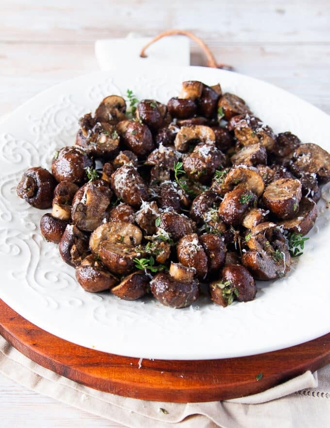 The mushrooms added into a plate and sprinkled with extra parmesan cheese