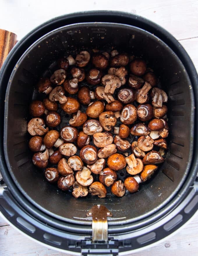 The mushrooms placed in the air fryer in a single layer 