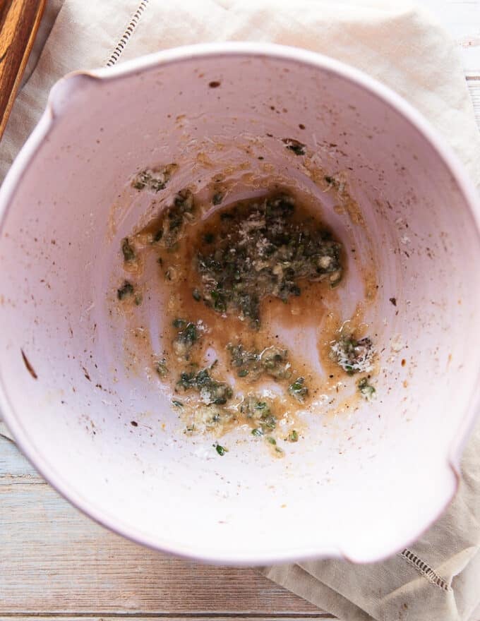 The melted butter , Parmesan , seasoning and fresh herbs is added to a large bowl.