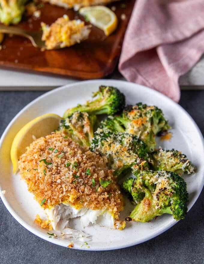 a plate of baked cod recipe with one bite taken off showing the texture