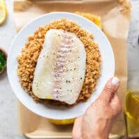 the mustard side of the fish dipped into the toasted bread crumbs and a hand pressing it down