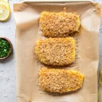 cod fish with the tops coated in panko breadcrumbs on a baking sheet ready to go in the oven