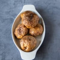 A plate of baked potatoes whole