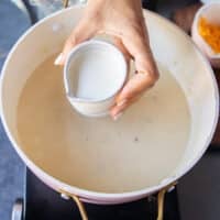 Cream is being poured into the soup pot