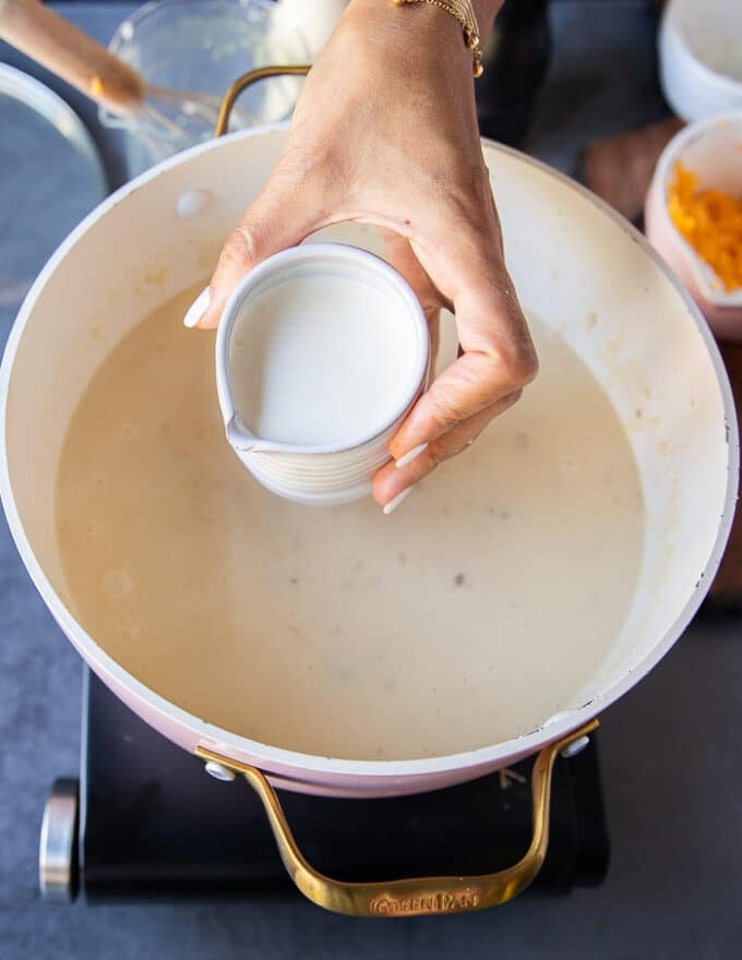Cream is being poured into the soup pot