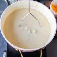 A hand masher used to inside the pot to slightly mash the potatoes in the baked potato soup recipe