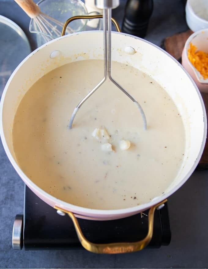 A hand masher used to inside the pot to slightly mash the potatoes in the baked potato soup recipe