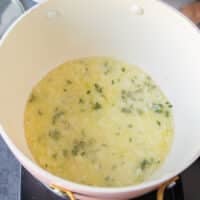 Onions and garlic sauteeing in butter with fresh thyme to make the soup base