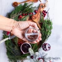 A hand holding a 2 inch cookie cutter showing the size and round cutter to be used on puff pastry