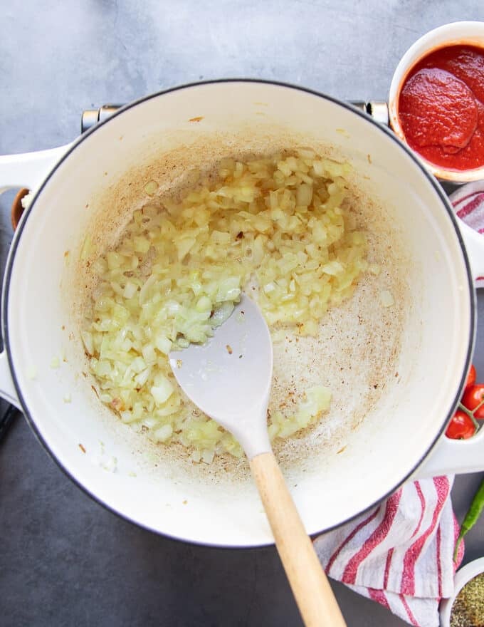 The onion is cooking in oil in a large soup pot to make taco soup