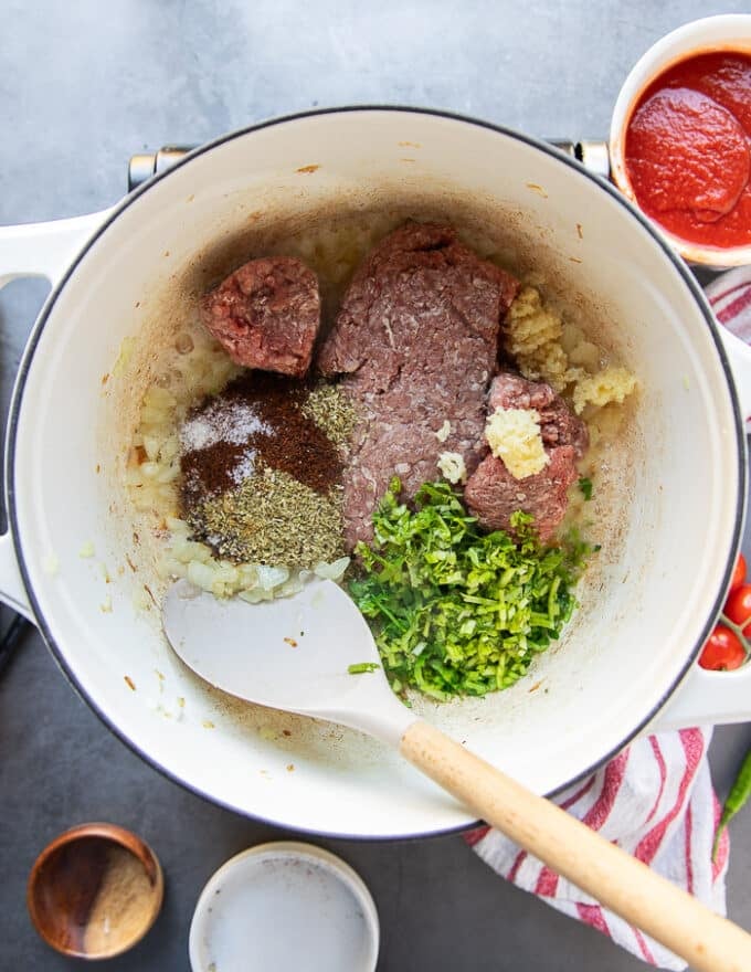 The ground beef, garlic, cilantro, and spices are added to the pot with the onions to cook the taco soup