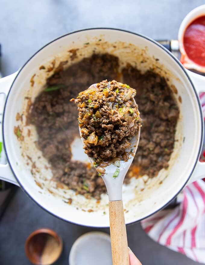 A spatula holding off the ground beef mixture close up showing how well cooked the meat is 