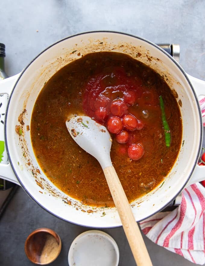 The canned cherry tomatoes in their juices are added in the taco soup pot along with the stock and one jalapeno