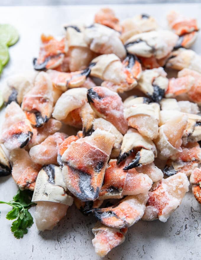 Frozen raw crab claws on a wooden board