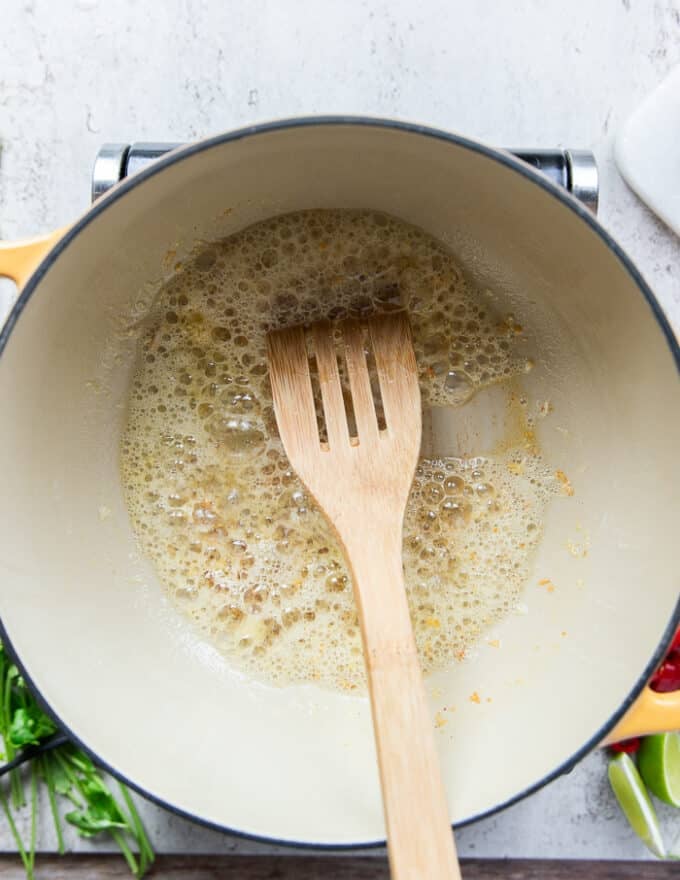 Butter heating up in a large pot with garlic sautéing over medium heat