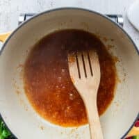 Seasoning and the sweet chilli sauce is added to the garlic in the pot