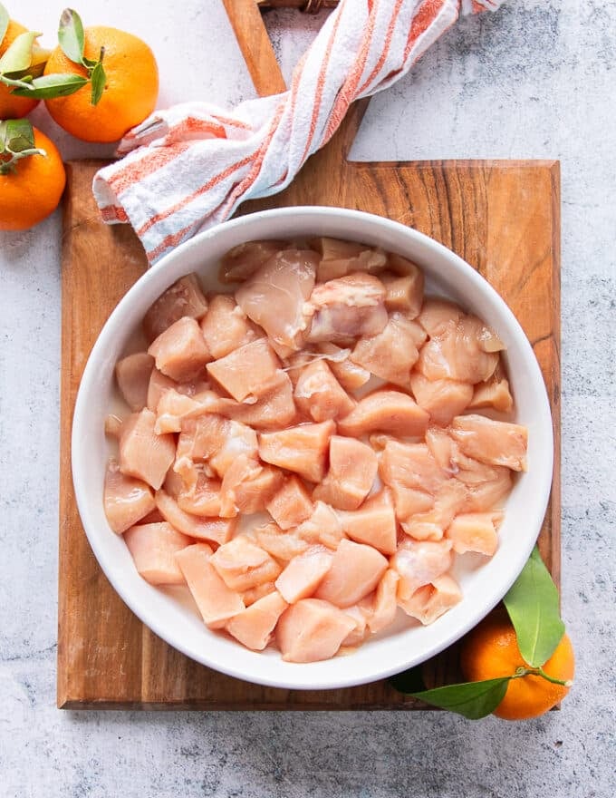 Chunks of chicken breasts and thighs boneless cut int 1 inch cubes in a plate