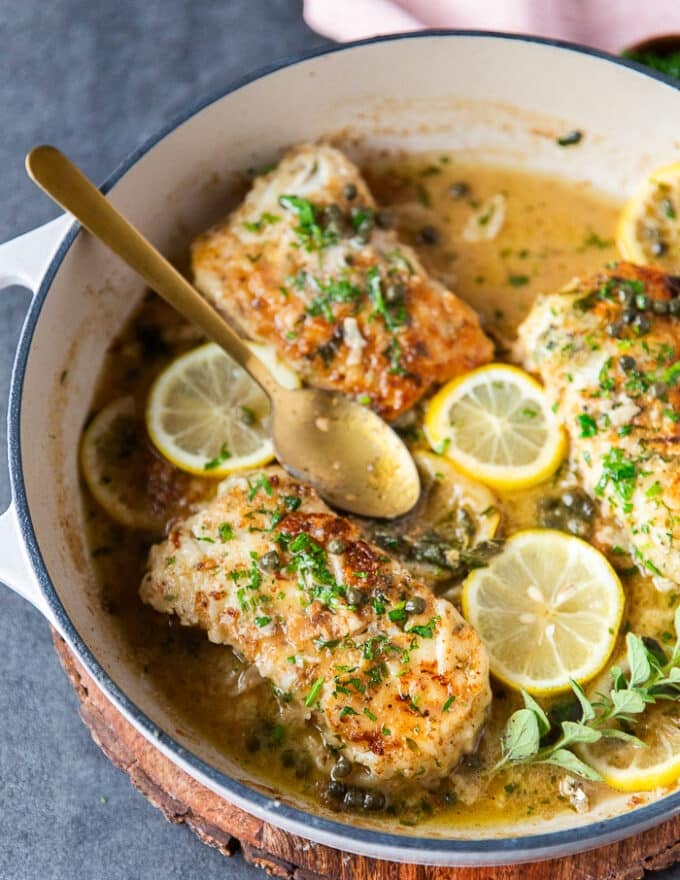 close up of the pan seared cod in the pan laced with lemon butter and capers 