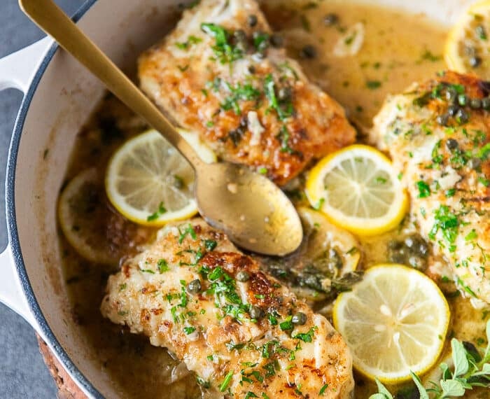 close up of the pan seared cod in the pan laced with lemon butter and capers
