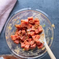 The fresh ahi tuna or saku tuna added into the bowl of seasoning and tossed using a spatula