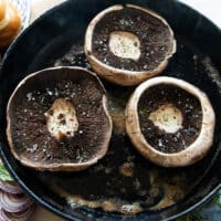 seasoned portobello mushrooms on a grill tops side down
