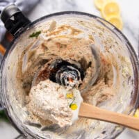 a spatula scooping out the smoked salmon dip in the food processor showing the texture close up