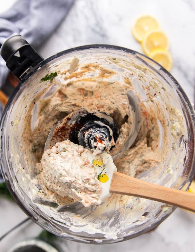 a spatula scooping out the smoked salmon dip in the food processor showing the texture close up
