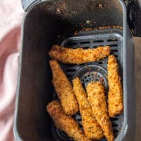 Fish Fingers in an air fryer basket perfectly cooked and golden.