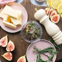 The ingredients for the butter added in a food processor to make the rosemary butter