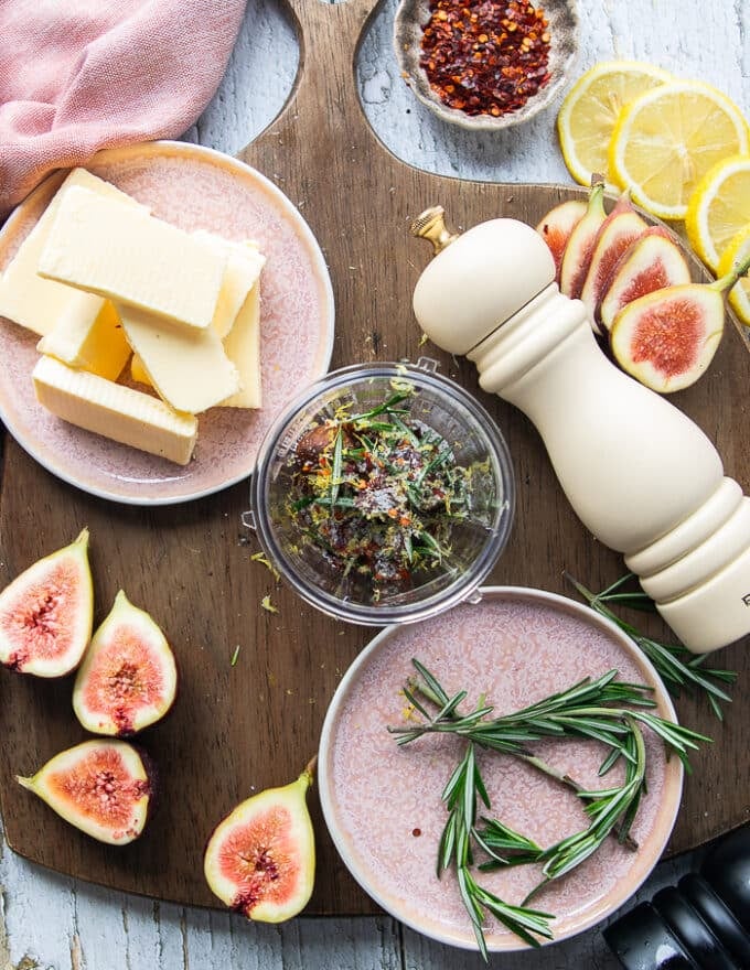 The ingredients for the butter added in a food processor to make the rosemary butter 