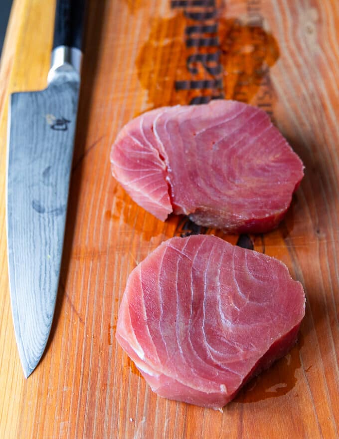 Fresh ahi tuna steaks on a wooden board to make sushi bake with