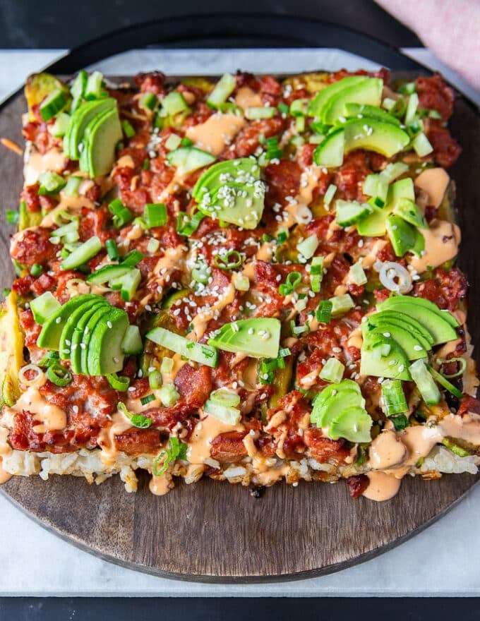 some sliced avocados, green onions, cucumbers, sesame seeds and a generous drizzle of spicy mayo is used to dress up the sushi bake after it come sout of the oven