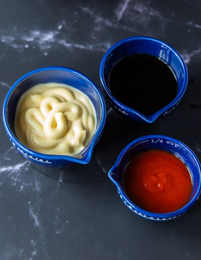 a bowl of kewpie mayo, a bowl of sriracha and a bowl of soy sauce to marinade the fish before baking 