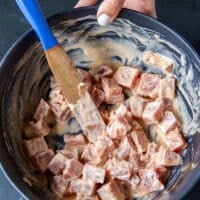 The fish is tossed with the spicy mayo marinade to flavor before baking