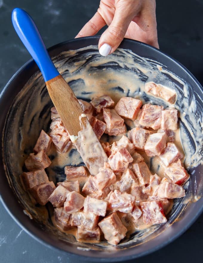 The fish is tossed with the spicy mayo marinade to flavor before baking