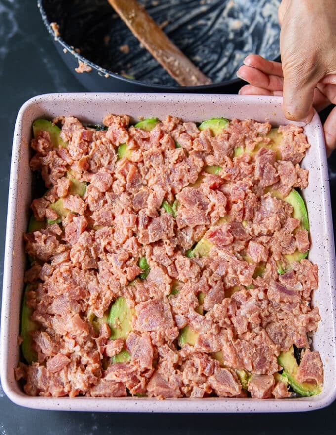 The sushi fish mixture is spread on top of the avocado layer in the baking pan and now it's ready to bake
