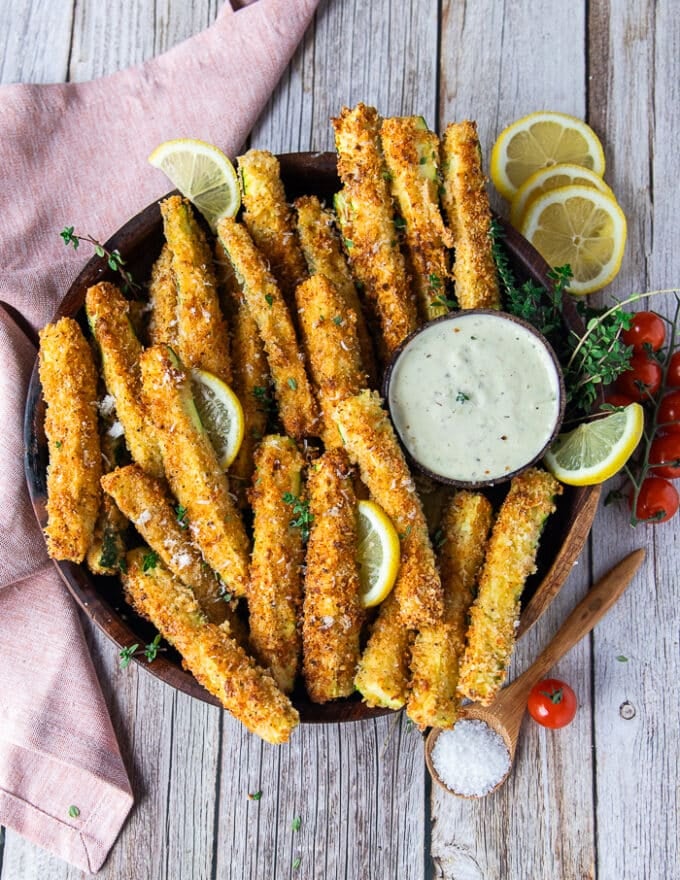 The final plate of zucchini fries served with dipping sauce, lemon slices and ready to eat 