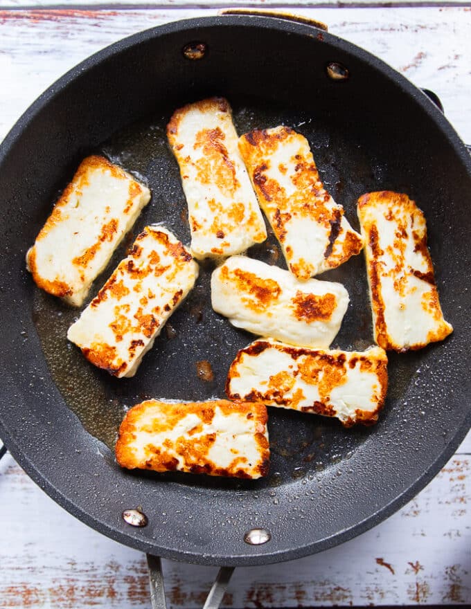 Golden pan fried halloumi cheese in a skillet 