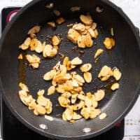 Golden toasted slivered almonds in a pan with chilli flakes