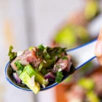 close up of a spoonful of tuna ceviche served as an appetizer with seaweed