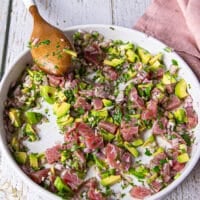 A wooden spoon mixing in all the ceviche recipe ingredients