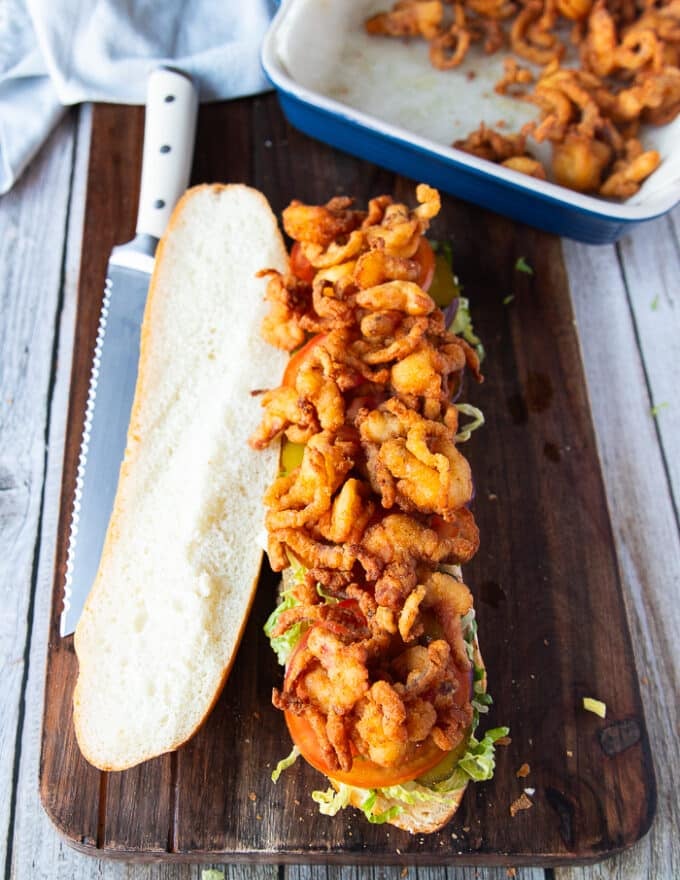 Fried shrimp or seafood is piled right ontop of the sandwich toppings